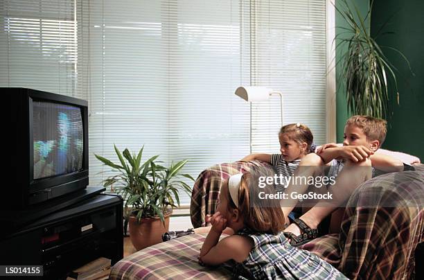 children watching tv - armrest stock pictures, royalty-free photos & images