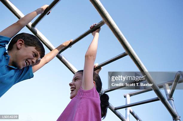 children hanging on jungle gym - jungle gym ストックフォトと画像