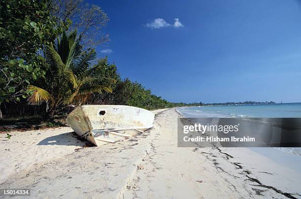 old boat wrecked on a white sand beach - greater antilles foto e immagini stock