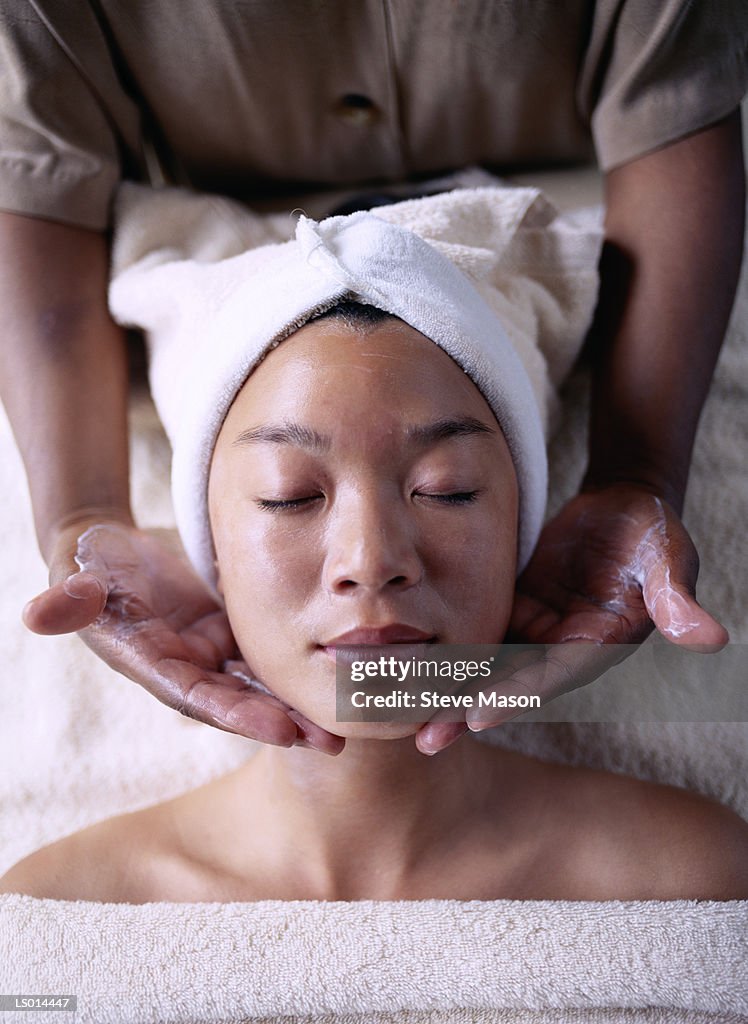 Young woman getting facial massage