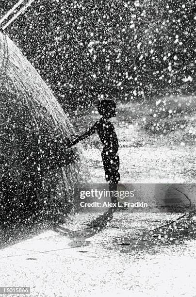 boy (4-6) playing in fountain, silhouette (b&w) - alex boys stockfoto's en -beelden