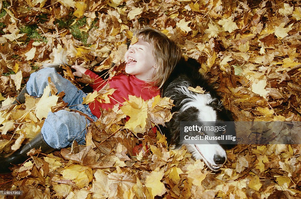 Girl and Dog in Autumn Leaves
