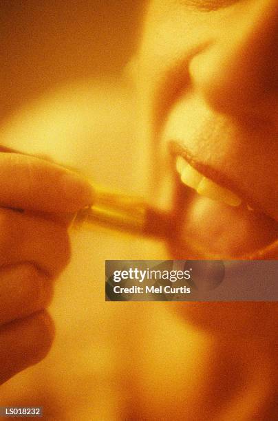 woman applying lipstick - curtis stockfoto's en -beelden