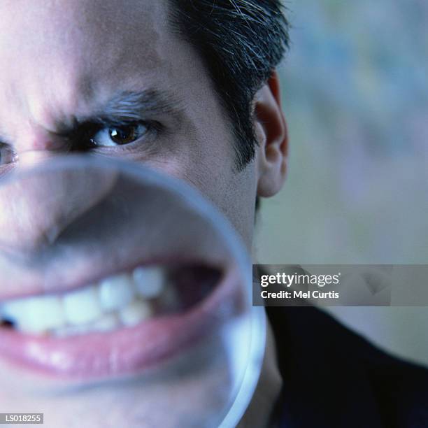 angry mouth in magnifying glass - curtis stock pictures, royalty-free photos & images