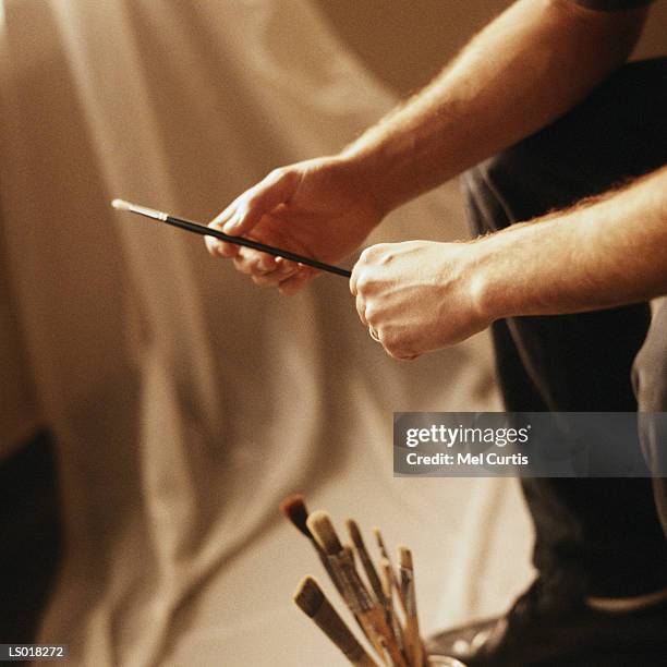 artist holding a paintbrush - curtis stockfoto's en -beelden