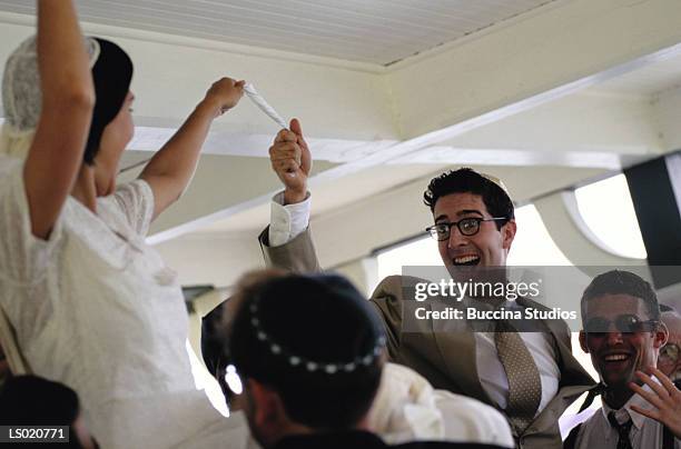 bride and groom holding scarf - jewish wedding dancing stock pictures, royalty-free photos & images