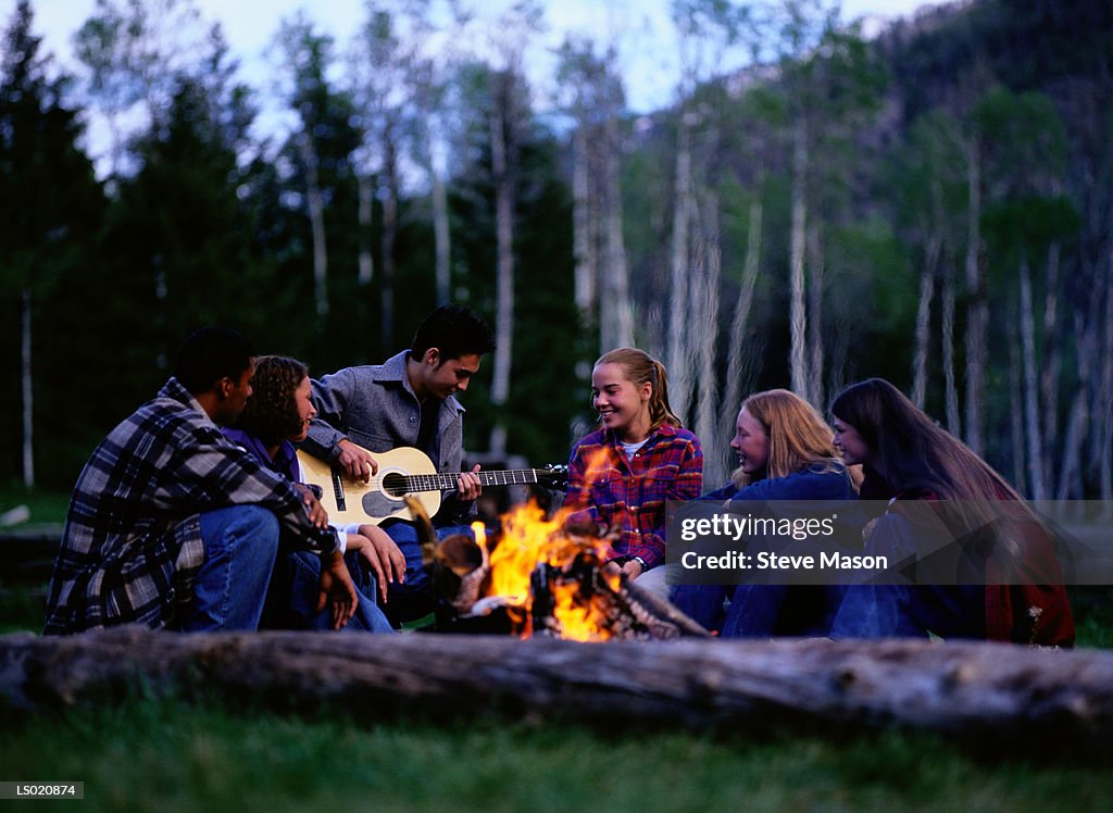 Teen Friends Singing Around Campfire