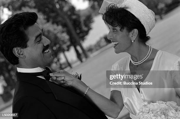 bride straightening groom's bow tie - pillbox hat stock pictures, royalty-free photos & images