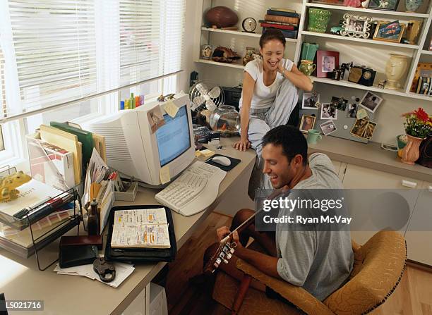 man playing the guitar in front of his computer - ergonomic keyboard stock pictures, royalty-free photos & images