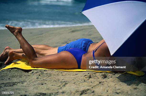 couple under a beach umbrella - amanda blue stock pictures, royalty-free photos & images