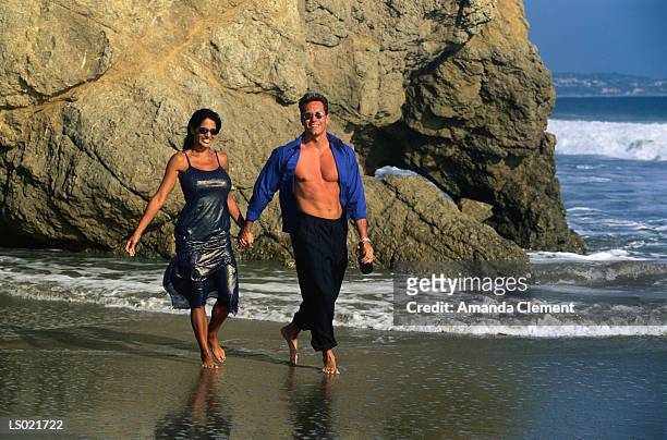 couple walking on a beach - amanda blue stock pictures, royalty-free photos & images