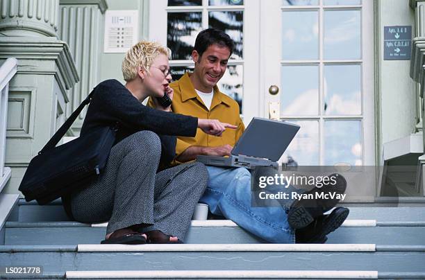 man and woman working at the top of the stairs - woman sitting top man stock pictures, royalty-free photos & images