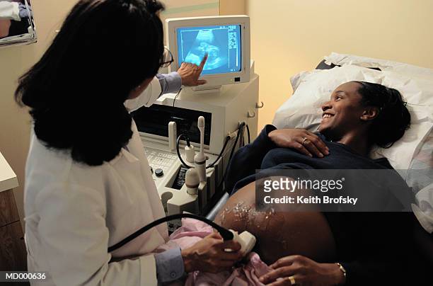 pregnant woman seeing her baby on ultrasound - abdomen scan stock pictures, royalty-free photos & images