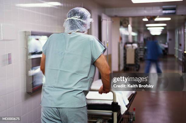 man pushing an empty stretcher in a hospital - hospital gurney fotografías e imágenes de stock
