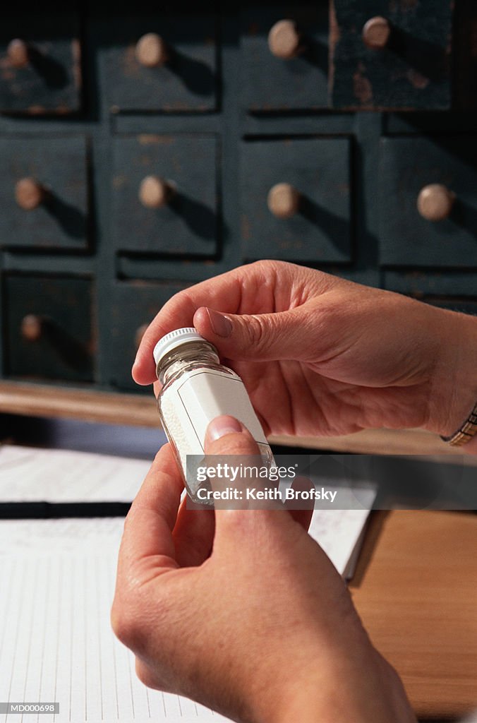 Woman Holding a Bottle of Homeopathic Medicine