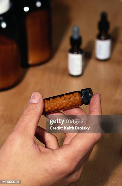 hand holding a bottle of homeopathic medicine - sal de la higuera fotografías e imágenes de stock