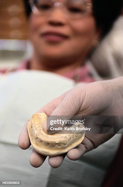 dentist holding a mold for dentures - molde dental fotografías e imágenes de stock