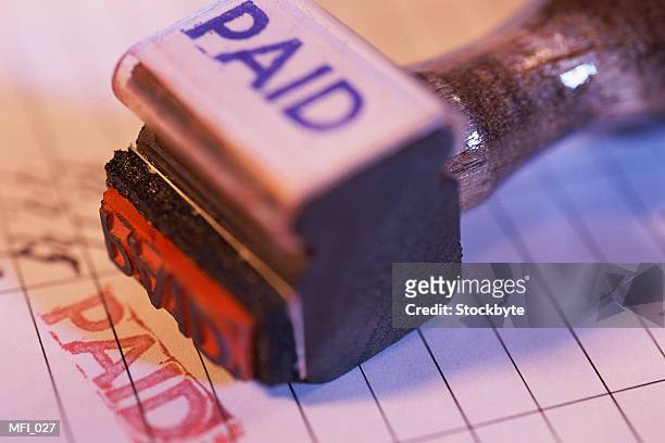 rubber stamp marked paid on top of stamped document - stamp foto e immagini stock