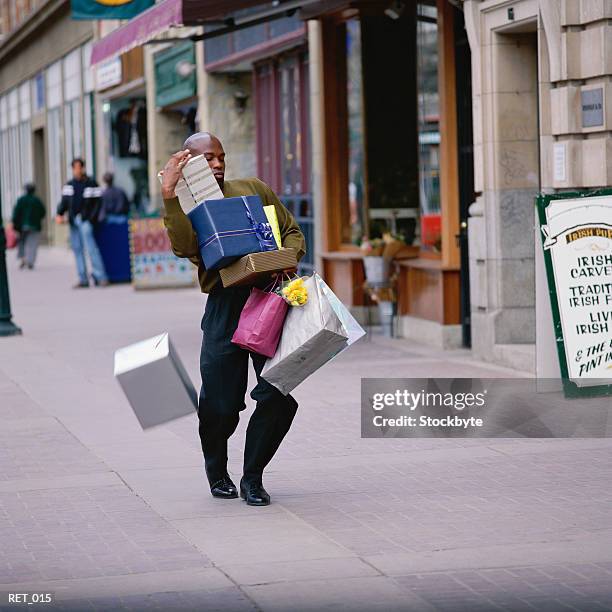 man dropping box, carrying pile of presents and shopping bags - carrying bags stock pictures, royalty-free photos & images