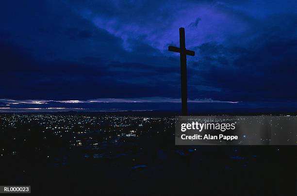 cross on hill above town, silhouette, twilight - town imagens e fotografias de stock