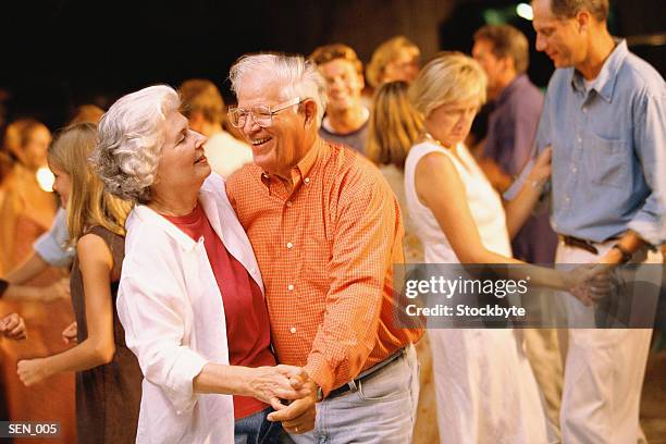 man and woman dancing among a group of people - ballroom stock pictures, royalty-free photos & images