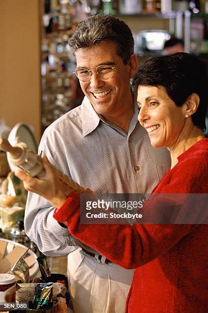 man and woman in kitchenware store; woman holding rolling pin - rolling pin stock-fotos und bilder