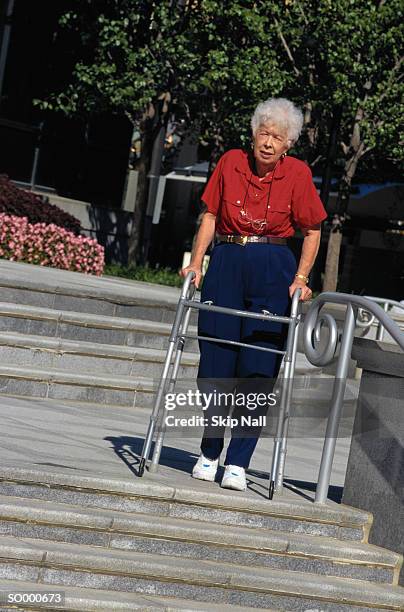 woman with walker at steps edge - step walker stock-fotos und bilder