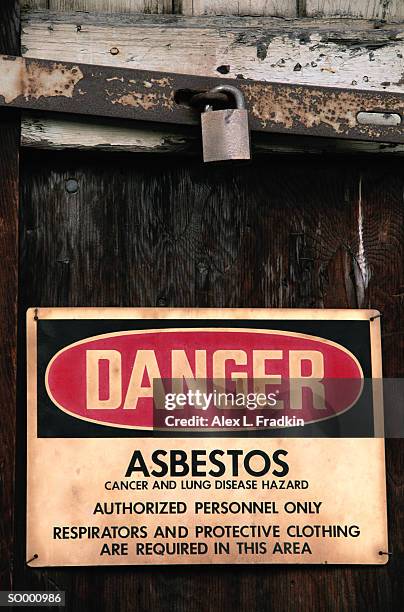 asbestos warning sign on door, close-up - door stockfoto's en -beelden