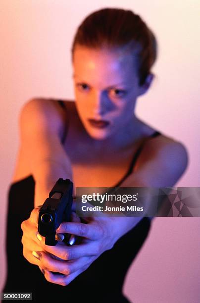 woman pointing gun - pink pistols stock-fotos und bilder