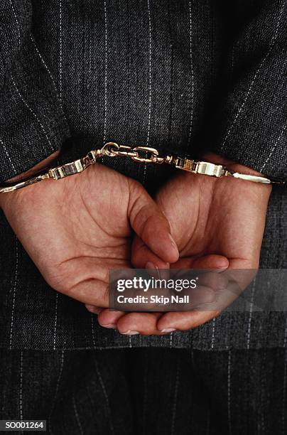 handcuffed hands - restraining device stock pictures, royalty-free photos & images
