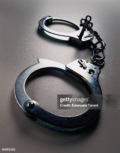 handcuffs close-up - restraining device stock pictures, royalty-free photos & images