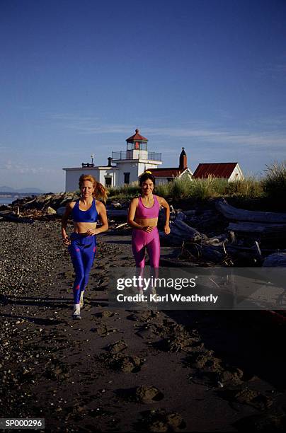 two women running - north pacific ocean stockfoto's en -beelden
