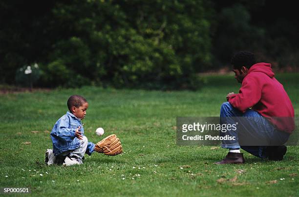 father and son playing catch - playing catch stock pictures, royalty-free photos & images