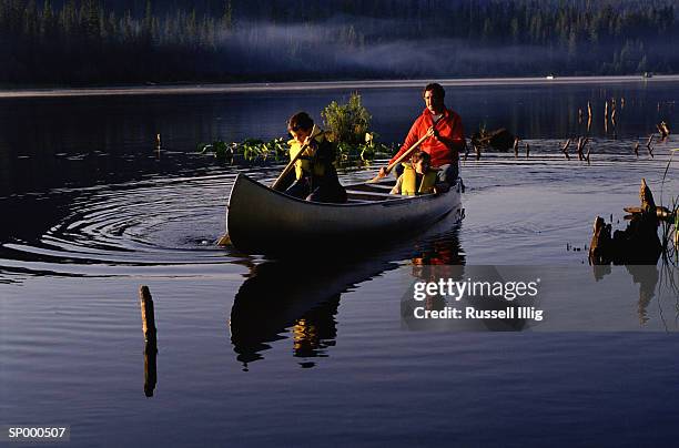 father and sons canoeing - marine safety equipment stock pictures, royalty-free photos & images
