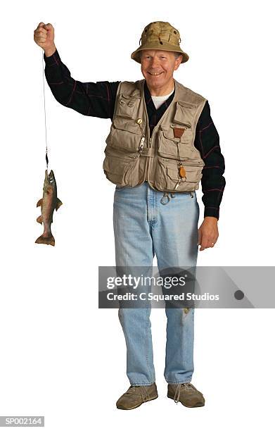 fisherman holding a fish - fiskeväst bildbanksfoton och bilder