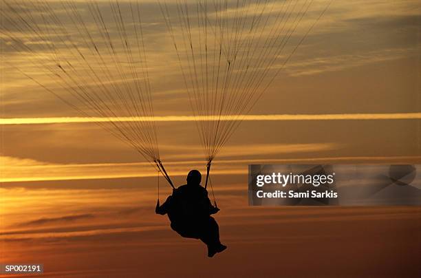 parasailing at sunset - luftsport stock-fotos und bilder