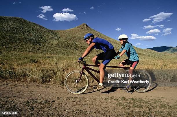 couple riding a tandem bicycle - tandem bicycle foto e immagini stock