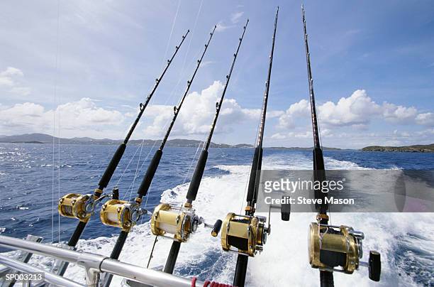 saltwater fishing rods affixed to boat's stern - angel stock-fotos und bilder