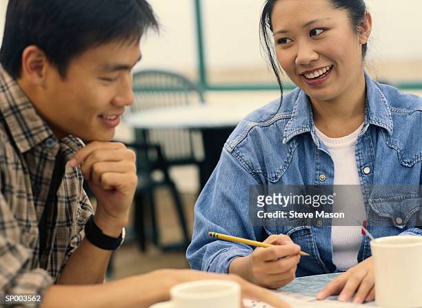 couple doing crossword at breakfast - crossword stock pictures, royalty-free photos & images