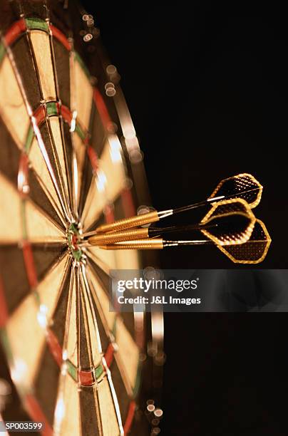 three darts in bull's-eye, close-up - bull stock-fotos und bilder