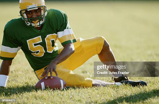 football player sitting on field - football player imagens e fotografias de stock