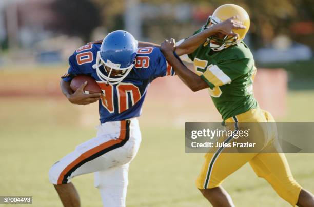 holding off tackle - american football uniform stock pictures, royalty-free photos & images