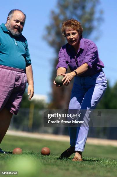 man and woman lawn bowling - lawn bowling stock-fotos und bilder