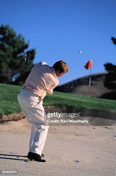 man hitting a golf ball out of a sand trap - off target stock pictures, royalty-free photos & images