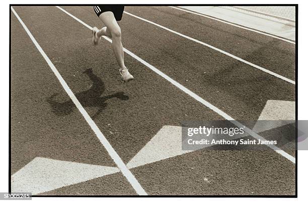 athlete and shadow on running track - saint anthony stock pictures, royalty-free photos & images