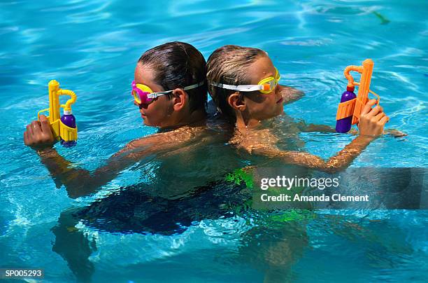 children in swimming pool with water pistols - amanda blue stock pictures, royalty-free photos & images