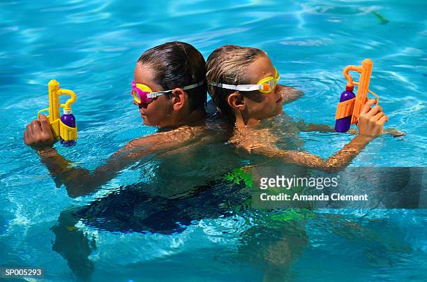 children in swimming pool with water pistols - amanda and amanda 個照片及圖片檔