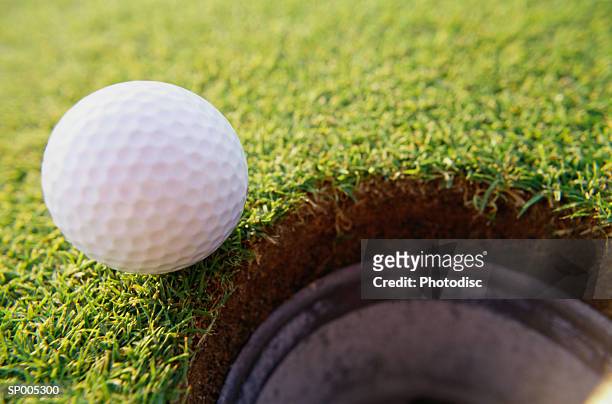 golf ball at the edge of a hole - off target stock pictures, royalty-free photos & images