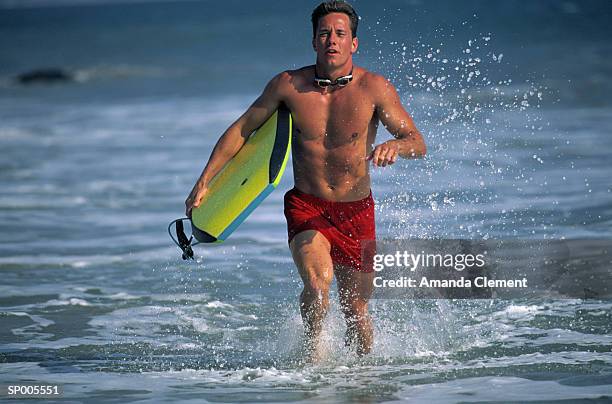 man running with a surfboard - amanda and amanda fotografías e imágenes de stock