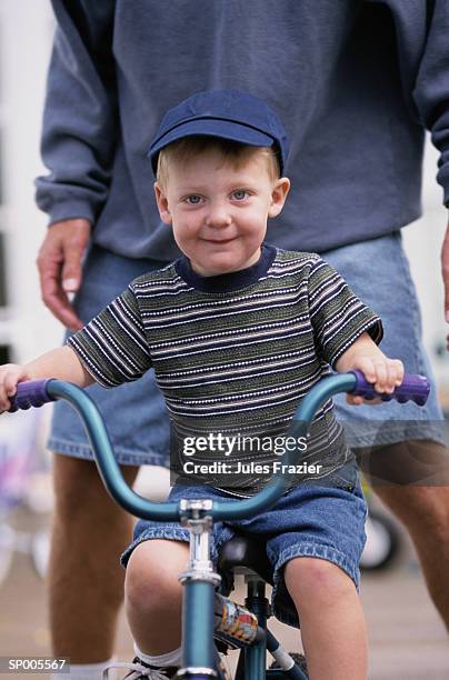 boy learning how to ride a bicycle - how fotografías e imágenes de stock